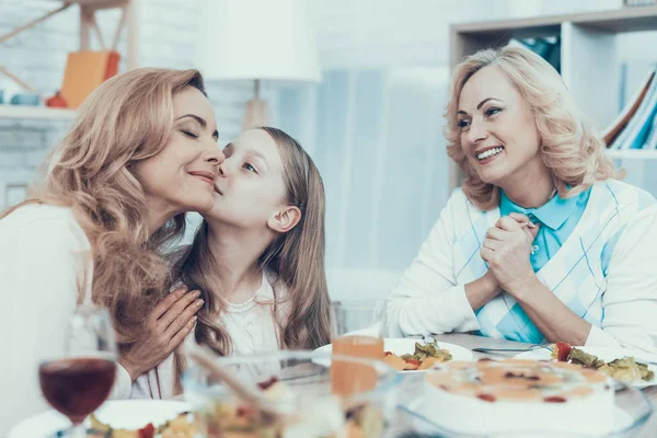 Family Celebrating Mother's Birthday at Home. Cake on Table. Happy Family. Mother with Daughter. Smiling Women. Smiling Grandmother. Celebration Concept. Glass of Wine. Hugging Together.