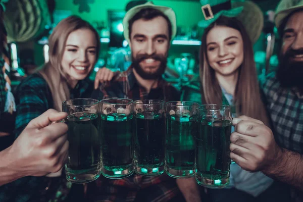 セント パトリック デーのパーティー 友人のグループは トーストと緑のビールです 友人は 若い男性と女性です 緑の帽子を身に着けている人々 幸せと笑顔です パブのインテリア — ストック写真