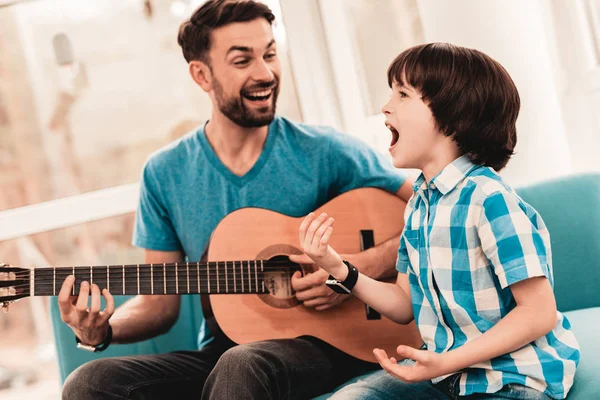 年轻的胡子父亲和儿子一起玩吉他 快乐的家庭概念 音乐人在家里 穿衬衫的小男孩 现代爱好概念 音乐和歌曲概念 微笑的人 — 图库照片