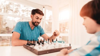 Sakallı baba ve oğul masaya satranç oynuyor. Mutlu aile kavramı. Tablo gemide. Genç çocuk gömlek. Kapalı sevinç. Masa oyunları kavramı. Modern hobi kavramı. Siyah beyaz resimler.