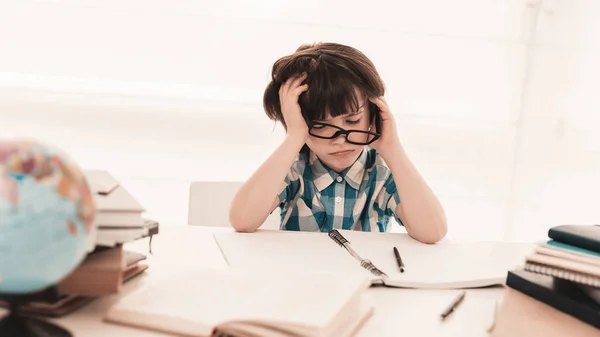 Niño Sentado Con Gafas Haciendo Tarea Educación Casa Mesa Blanca —  Fotos de Stock