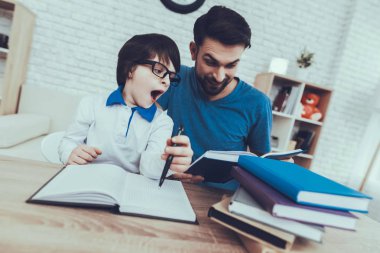 Adam oğluyla vakit geçiriyor. Çocuk Baba çocuk yetiştirme devreye girer. Babası gülümseyen bir kitap okuyor. Bardaklarda Yawning bir çocuktur. İnsanlar masada oturuyor. Evde bulunan insanlar.
