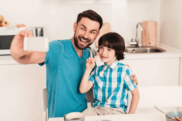 Pai Filho Felizes Usando Smartphone Casa Rapaz Sorridente Cozinha Moderna — Fotografia de Stock
