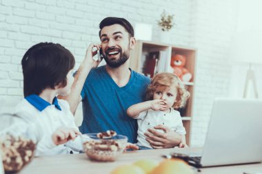 Baba çocuk yetiştirme devreye girer. En büyük oğulları bir kahvaltı yemek yiyor. Çalışma ve Talking cep telefonu üzerinde babasıdır. Adam genç oğlu tutuyor. İnsanlar masada oturuyor. Evde bulunan insanlar.