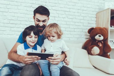 Oğulları ile zaman geçirir. Baba çocuklar yetiştirme çocuklarda devreye girer. Baba ve oğulları Tablet Pc. kişi hakkında bir Video kanepede oturan izliyor. İnsanlar yatak odasında yer alan.
