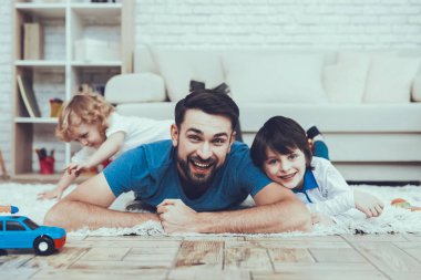 Oğulları ile zaman geçirir. Baba çocuk yetiştirme devreye girer. Baba ve yaşça en olduğunu Lying halı üzerinde ve gülen. Küçük oğlu oynarken arka plan üzerinde yalnızdır. İnsanlar yatak odasında yer alan.