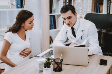 Hamile kız, jinekolog doktor. Doktor bir genç adam doktor gösterilen kadın tablet bir şeydir. Kadın dokunmadan Her adamıdır. Masada oturan insanlar. Kliniği'nde yer alan insanlar.