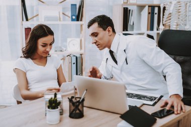 Hamile kız, jinekolog doktor. Doktor bir genç adam doktor gösteren kadın için ultrason sonuçları. Masada oturan insanlar. Gülen bir kadındır. Kliniği'nde yer alan insanlar.