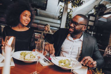 Afrika kökenli Amerikalı çift restoranda. Aşk dating romantik çift. Neşeli erkek ve kadın menüsüyle restoran yapma sırayla. Romantik kavramı. Yıldönümü. Tarih. Aşk.