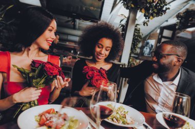 Çift Kişilik Çift aşk restoranda kalma. Arkadaşlar bir restoranda romantik akşam zevk. Grup Happy Friends restoranda Dating tadını çıkarıyor. Romantik kavramı. Buket kırmızı gül. Aşk kavramı.