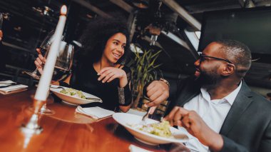 Afrika kökenli Amerikalı çift restoranda. Aşk dating romantik çift. Neşeli erkek ve kadın menüsüyle restoran yapma sırayla. Romantik kavramı. Yıldönümü. Tarih. Aşk.