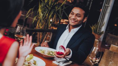Kız arkadaşıma evlenme teklif İspanyol yakışıklı adam. Aşk dating romantik çift. En adam ve kız bir restoranda. Romantik kavramı. Bir evlenme teklifi almak çekici kadın şaşırttı.