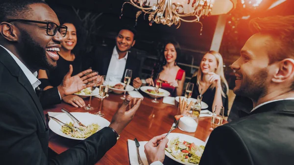 Group of Happy Friends Meeting and Having Dinner. Celebrating with Friends. Party Dinner Table. Enjoying Meal In Restaurant. Restaurant Chilling Out Classy Lifestyle Reserved Concept.