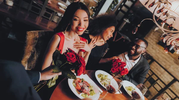 Double Couple in Love Dating in Restaurant. Friends in a Restaurant Enjoying Romantic Evening. Group Happy Friends Enjoying Dating in Restaurant. Romantic Concept. Bouquet Red Roses. Love Concept.