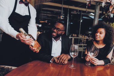 Afrikalı çift Offerring şişe şarap restoran. Afrika kökenli Amerikalı çift sipariş restoranda yapma. Aşk dating romantik çift. Romantik kavramı. Yıldönümü. Tarih. Seviyorum. Garson.