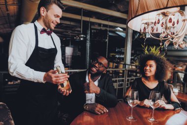 Afrikalı çift Offerring şişe şarap restoran. Afrika kökenli Amerikalı çift sipariş restoranda yapma. Aşk dating romantik çift. Romantik kavramı. Yıldönümü. Tarih. Seviyorum. Garson.