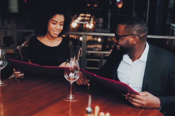 African American Couple Dating in Restaurant. Romantic Couple in Love Dating. Cheerful Man and Woman with Menu in a Restaurant Making Order. Romantic Concept. Anniversary. Date. Love.