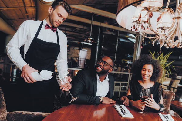 Garçom Derramando Vinho Para Casal Vidro Restaurante Casal Romântico Afro — Fotografia de Stock