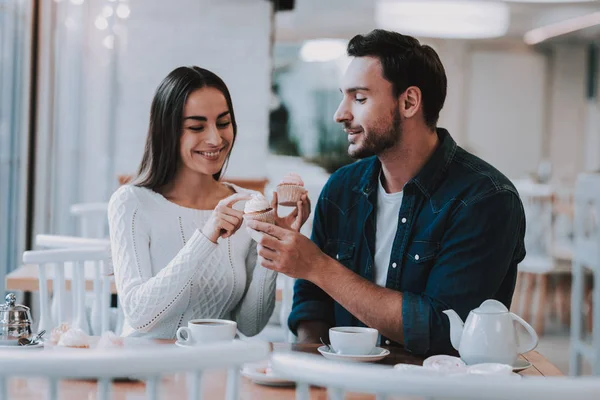 カップル カフェで休憩します カップルは美しい若い男と女です 女性は 触れること 人間のケーキです テーブルの上の紅茶 テーブルに座っています 幸せと笑顔です 晴れた昼間 — ストック写真