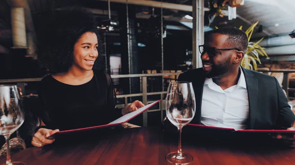 African American Couple Dating in Restaurant. Romantic Couple in Love Dating. Cheerful Man and Woman with Menu in a Restaurant Making Order. Romantic Concept. Anniversary. Date. Love.