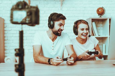 Blogcular bir Video yapar. Blogcular oyuncular var. Blogcular erkek ve kadın var. Kamera bir Video vuruyor. İnsanlar bir kulaklık takıyor. Konsolda bir Video oyunu oynayan insanlar. Studio iç insanlarda.