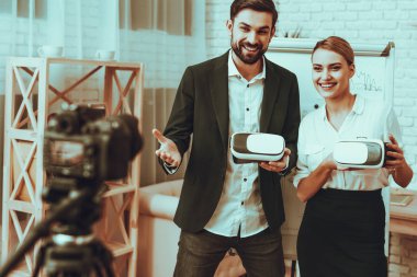 Blogcular bir Video yapar. Blogcular iş adamı ve iş kadını var. Bir yenilik hakkında video. Kamera bir Video vuruyor. Bir sanal gerçeklik gözlük gösterilen kişiler. Gülen kişidir. Studio iç.