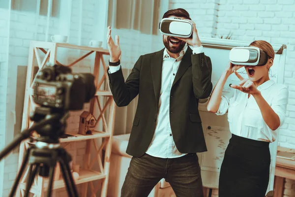 Bloggers Makes a Video. Bloggers is Businessman and Businesswoman. Video About a Innovation. Camera Shoots a Video. Persons Wearing a Virtual Reality Glasses. People is Surprised. Studio Interior.