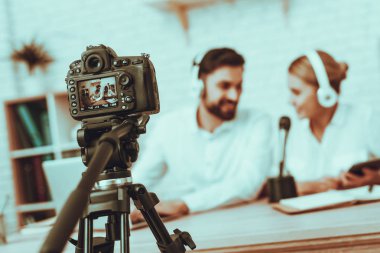 Bulanık görüntü blogcular bir Video yapar. Blogcular gülümseyen erkek ve kadın var. Kamera bir Video vuruyor. İnsanlar bir kulaklık takıyor. Mikrofon, Talking kişidir. Studio iç insanlarda.