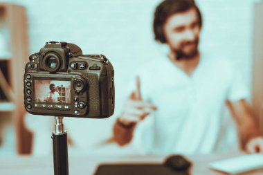 Blogger bulanıklık görüntü bir Video yapar. Blogger Gamer olduğunu. Blogger adam kamera bir Video çekimleri var. Bilgisayarda bilgisayar oyunu oynamak kulaklık adam. Seyir ve kamera işaret eden bir adam. Studio iç.