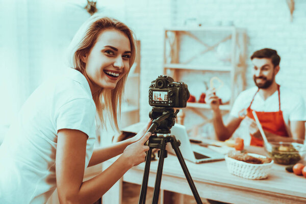 Размытый взгляд блогера делает видео. Видео о кулинарии. Оператор снимает видео на камеру. Женщина улыбается. Другая еда на столе. "Человек показывает кусочек перца". Персоналии: Интерьер студии
.