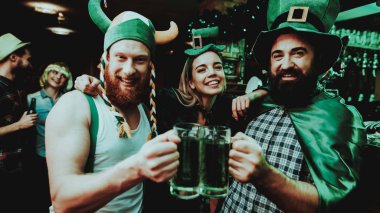 İki erkek ve kız Carnival şapka bira içiyor. St Patrick's Day kavramı kutlama. Bar Counter. Sakallı erkekler. İyi şenlikli ruh hali. Parlak ışıklar. Club ziyaretçi. Eğleniyor. Birlikte dinlenme.
