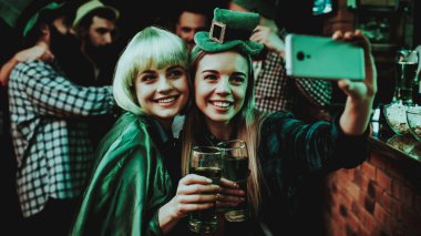 Selfie barda iki kız yapın. St Patrick's Day kavramı kutlama. Bar Counter. İyi şenlikli ruh hali. Parlak ışıklar. Club ziyaretçi. Eğleniyor. Birlikte dinleniyor. Bellek fotoğraf. Gülümseyen.