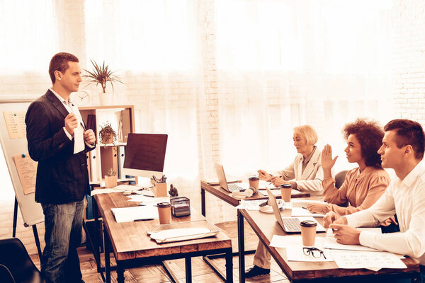 Учитель демонстрирует студентам новую информацию. Студенты - многорасовые люди разных возрастов. "Студентка поднимает руку". Студенты сидят за столами. Персоналии: Класс
.