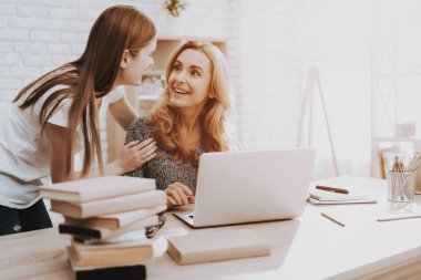 Anne ve kızı dizüstü evde izliyor. Kızı yardımcı anne. Anne ve kızı evde. Genç kız. Frilancing anne kavramı. Dijital aygıt kullanarak kadınlar. Gülümseyen kadın.