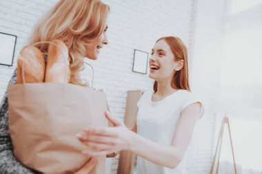 Paketleri gıda deposundan evde annesiyle. Kızı yardımcı anne. Sağlıklı gıda ve yaşam tarzı kavramı. Birlikte yemek. Ekmek çantada. Anne ve kızı evde. Genç kız.