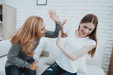 Anne kızı üzgün yakınındaki evde çığlık. Aile ilişkisi var. Endişeli anne. Mutsuz kız. Kavramı destekler. Korkmuş kişi. Kadınlar beyaz kanepe. Öfkeli anne. Endişeli kişi.