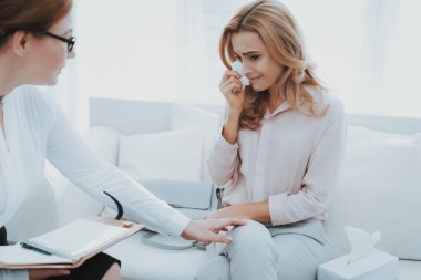 Psikolog'ın resepsiyonunda yetişkin bir kadın. O ağlıyor. Kadın psikolog onu sakinleştirmeye çalışır. Ofiste kanepede oturuyor.