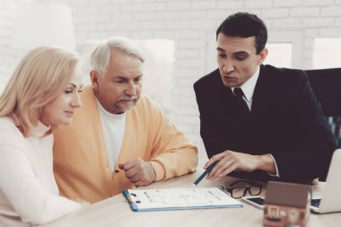 Erkek ve kadın ile Office Emlak Danışmanlık. Önemli belgeler. Emlak tasavvurları. Büyükbaba ve büyükanne. Gri saçlı insanlar. Genç Emlak takım elbiseli. Kiralık ev.