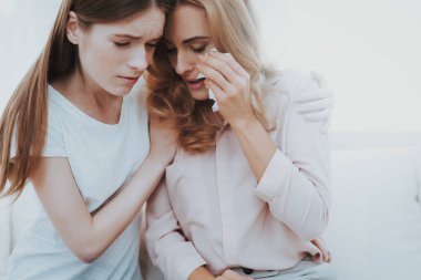 Kadın mutsuz genç kızı evde huzur veriyor. Evde kanepede oturan. Sorun olan kız. Aile çatışmada. Üst ve alt. Mutsuz kız. İletişim kavramı. İlişki kavramı.
