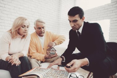 Erkek ve kadın ile Office Emlak Danışmanlık. Önemli belgeler. Emlak tasavvurları. Büyükbaba ve büyükanne. Gri saçlı insanlar. Genç Emlak takım elbiseli. Kiralık ev.