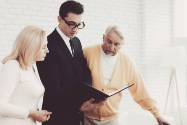 Yaşlı adam ve kadın ziyaret genç avukat ofiste. Önemli belgeler. Modern Hukuk Bürosu. Büyükbaba ve büyükanne. Gri saçlı insanlar. Genç savunucusu. Adalet ve Hukuk kavramları.