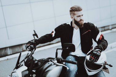 Deri ceketli adamı motosiklet üzerinde oturuyor. Geziye gidiyor. Moda binici. Kendine güvenen bakışları. Araç hız. Havalı motorcu sakallı. Motosiklet kavramı. Klasik tarzı. Sürücü hazır.