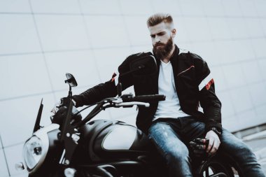 Deri ceketli adamı motosiklet üzerinde oturuyor. Geziye gidiyor. Moda binici. Kendine güvenen bakışları. Araç hız. Havalı motorcu sakallı. Motosiklet kavramı. Klasik tarzı. Sürücü hazır.