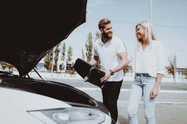 Tesla araba tankında bir çanta koyarak kadın ve erkek. Şarj istasyonu. Otomobil test. Yenilik teknoloji. Yeni nesil Electro hibrid araç eklenti. Güneşli bir gün. Futuristik güç.
