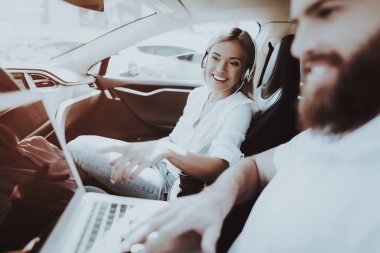 Adam Laptop ile çalışıyor. Kulaklık kız. Tesla araba. Ön koltuk. Yenilik teknoloji. Yeni nesil Electro hibrid araç. Lüks tasarım. Futuristik güç. Resring birlikte. Sürüş testi.