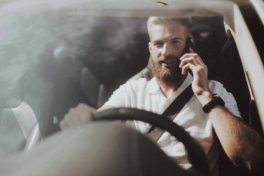 Adamın Tesla arabanın direksiyonuna bir telefon görüşmesi var. Yenilik teknoloji. Yeni nesil Electro hibrid araç. Lüks tasarım. Futuristik güç. Ön koltuk. Cam görünümü.