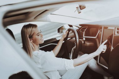 Tesla araba kadında. Arkasında tekerlek kavramı. Yenilik teknoloji. Yeni nesil Electro hibrid araç. Lüks tasarım. Futuristik güç. Ekranda ver. İç görünüm. Ön koltuk.