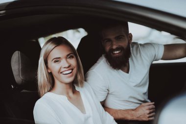 Tesla araba tekerlek arkasındaki adam. Ön koltuk kız. Yenilik teknoloji. Yeni nesil Electro hibrid araç. Lüks tasarım. Futuristik güç. Eller üstünde göstermek. Sürüş testi.
