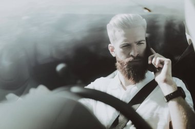Adamın Tesla arabanın direksiyonuna bir telefon görüşmesi var. Yenilik teknoloji. Yeni nesil Electro hibrid araç. Lüks tasarım. Futuristik güç. Ön koltuk. Cam görünümü.