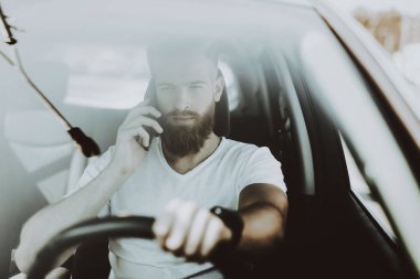 Adamın Tesla arabanın direksiyonuna bir telefon görüşmesi var. Yenilik teknoloji. Yeni nesil Electro hibrid araç. Lüks tasarım. Futuristik güç. Ön koltuk. Cam görünümü.